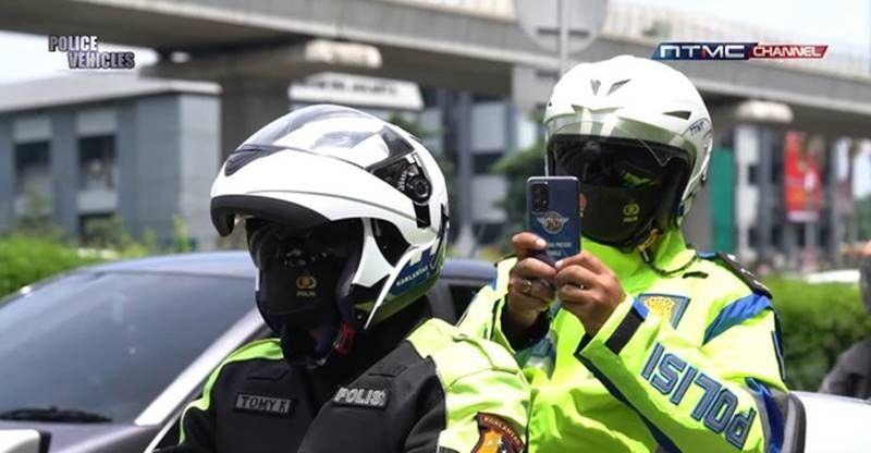 Petugas patroli merekam pelaku pelanggaran menggunakan smartphone